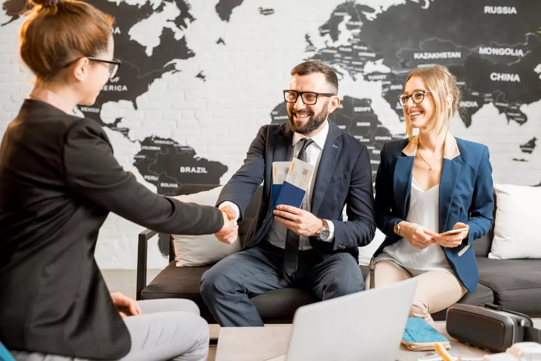 young-businesscouple-choosing-trip-with-agent-sitting-travel-agency-office-with-world-map-background(1)